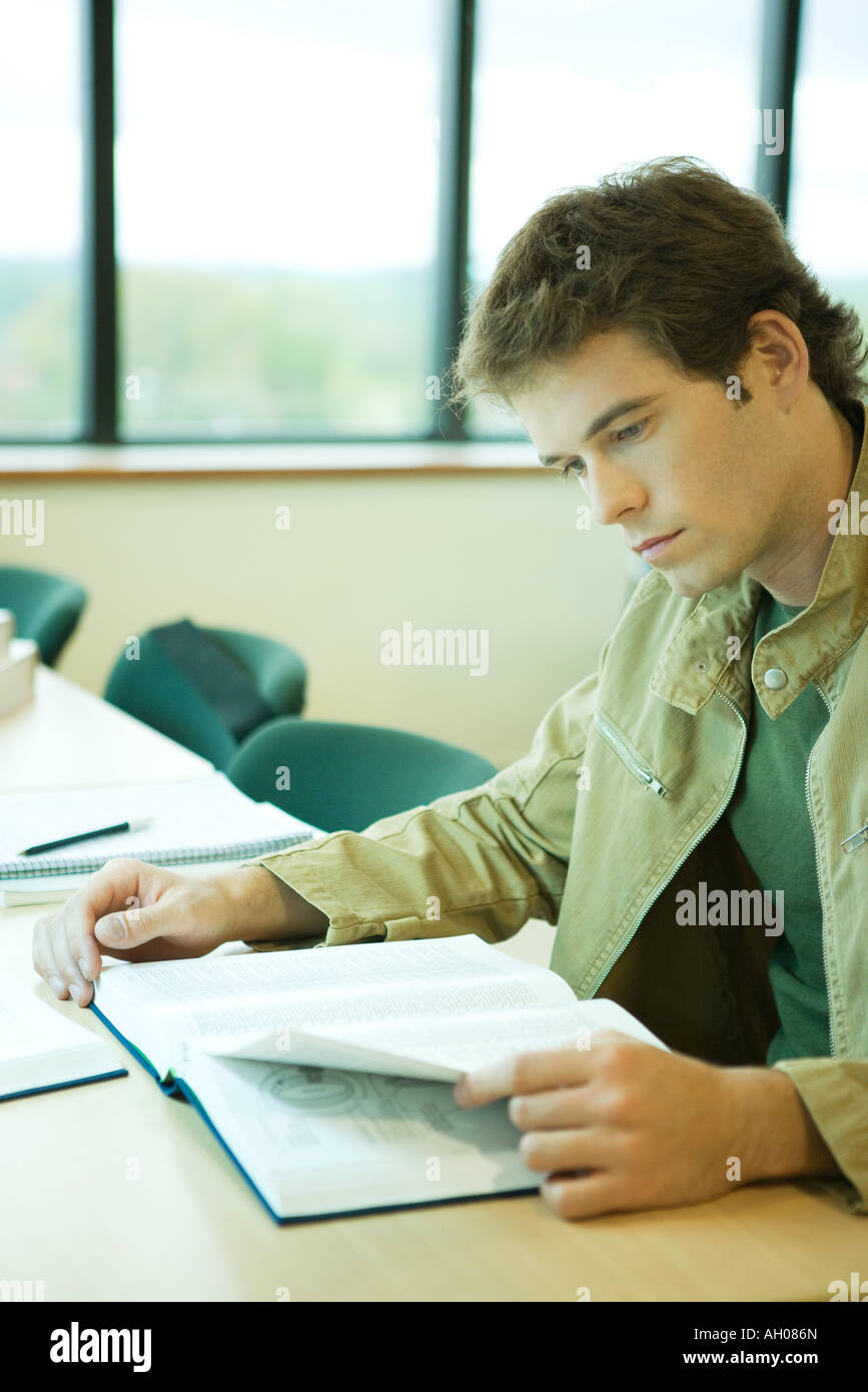 Young man studying in university library Stock Photo