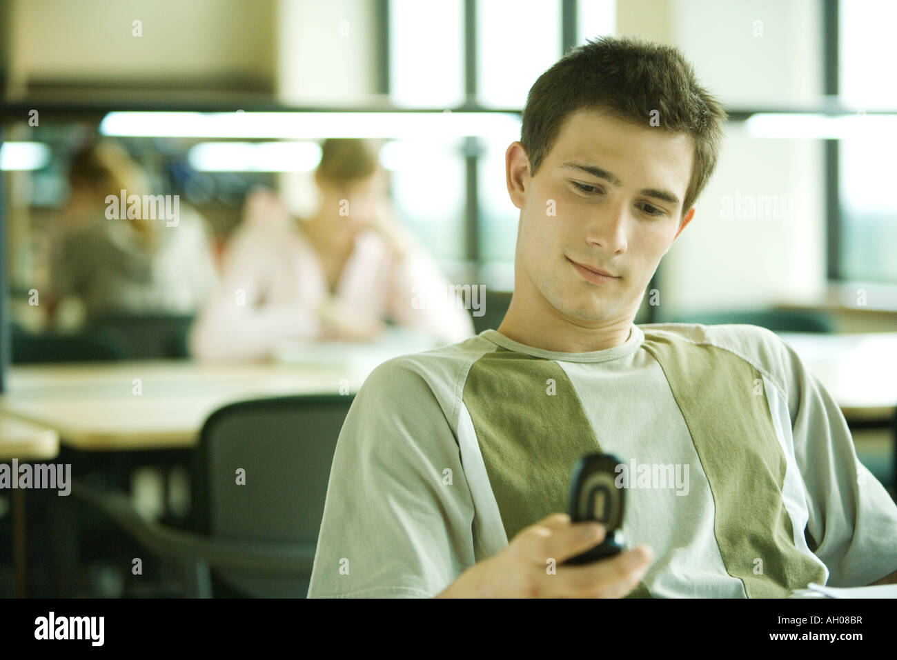 Library Study Phone Male student checking cell phone in library study area Stock Photo - Alamy