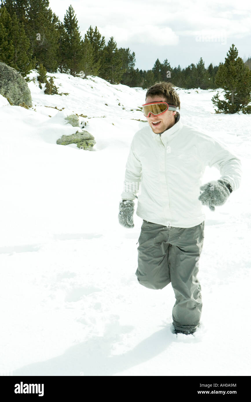 Young man running in snow, wearing ski goggles, full length Stock Photo -  Alamy