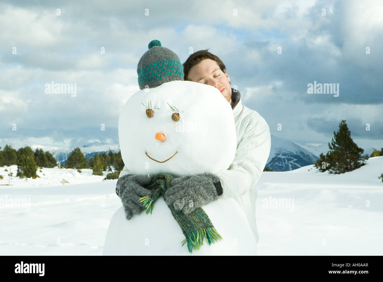 Young man embracing snowman, eyes closed, portrait Stock Photo - Alamy