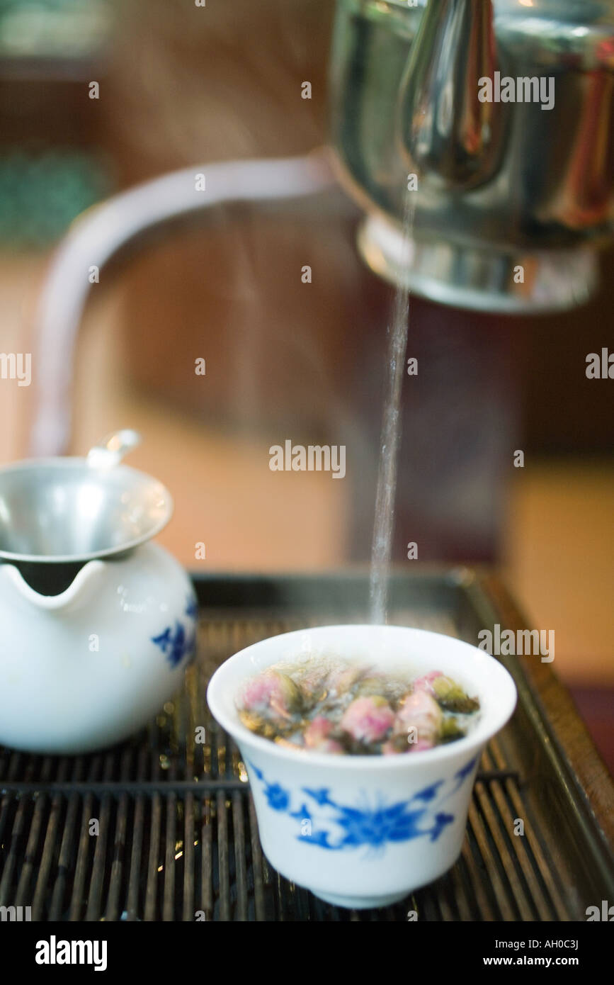 Pouring hot water into flower and tea mixture Stock Photo Alamy