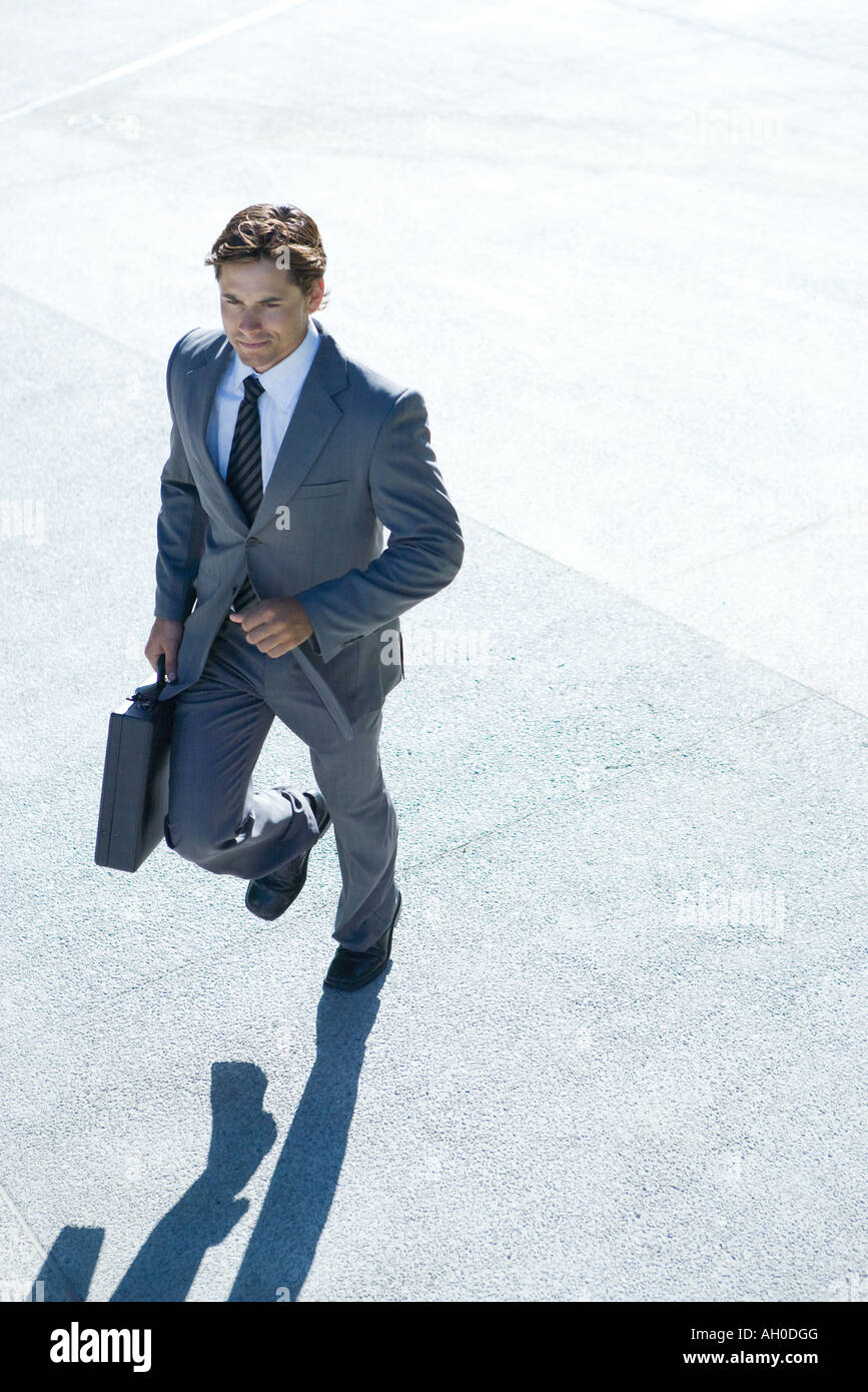 Businessman carrying briefcase, walking Stock Photo