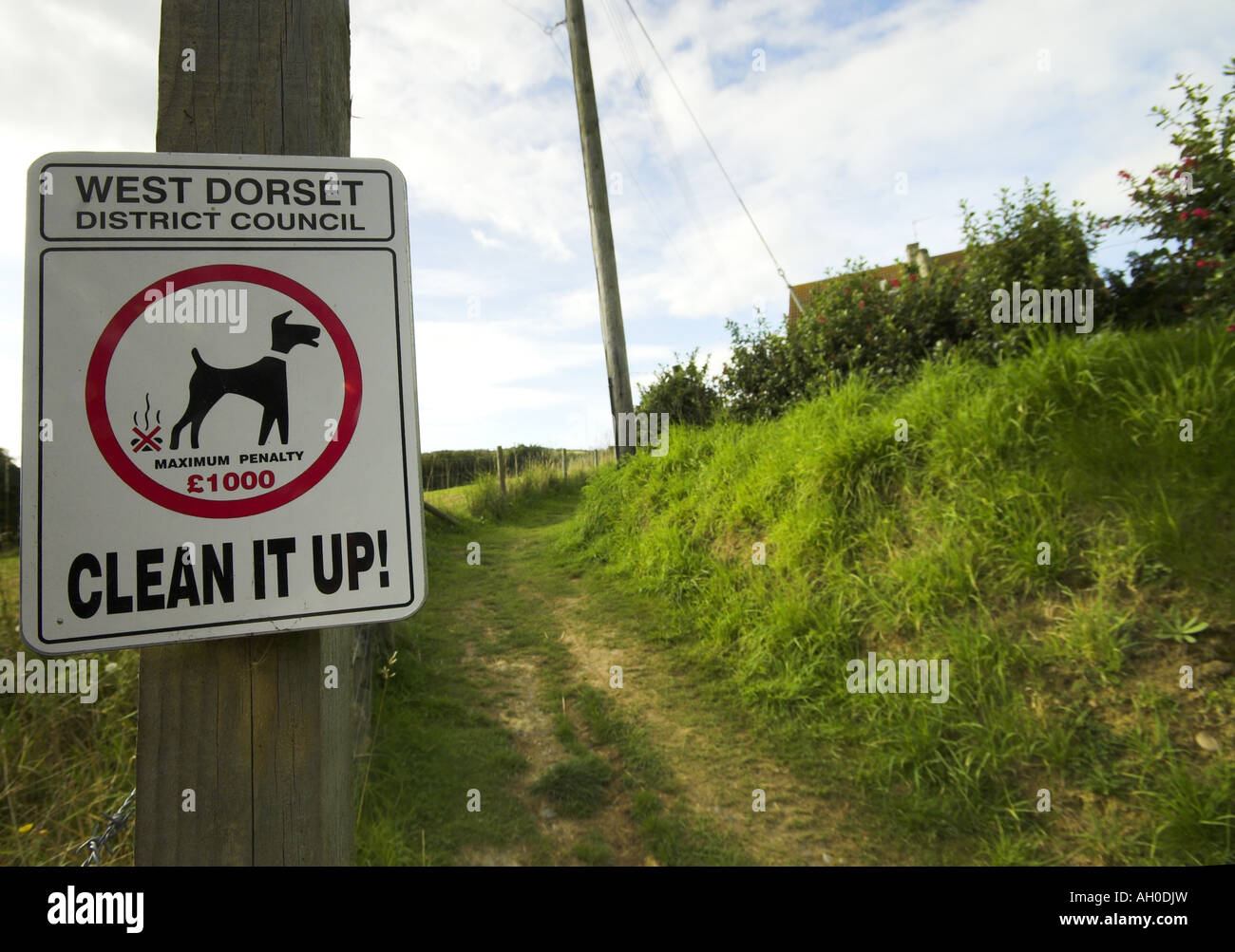 A sign post showing no fouling next to a foot path Stock Photo
