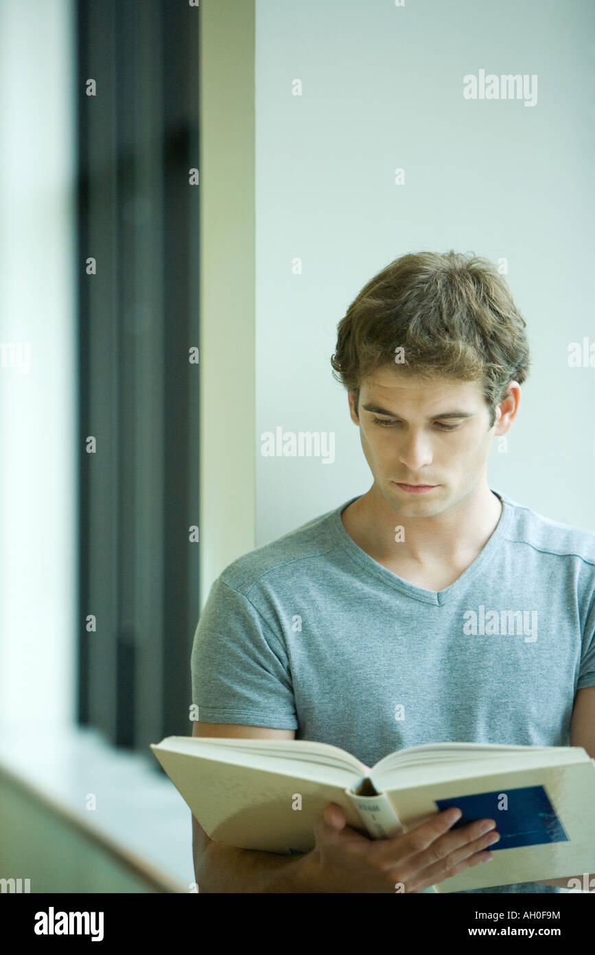 Young man reading book, close-up Stock Photo