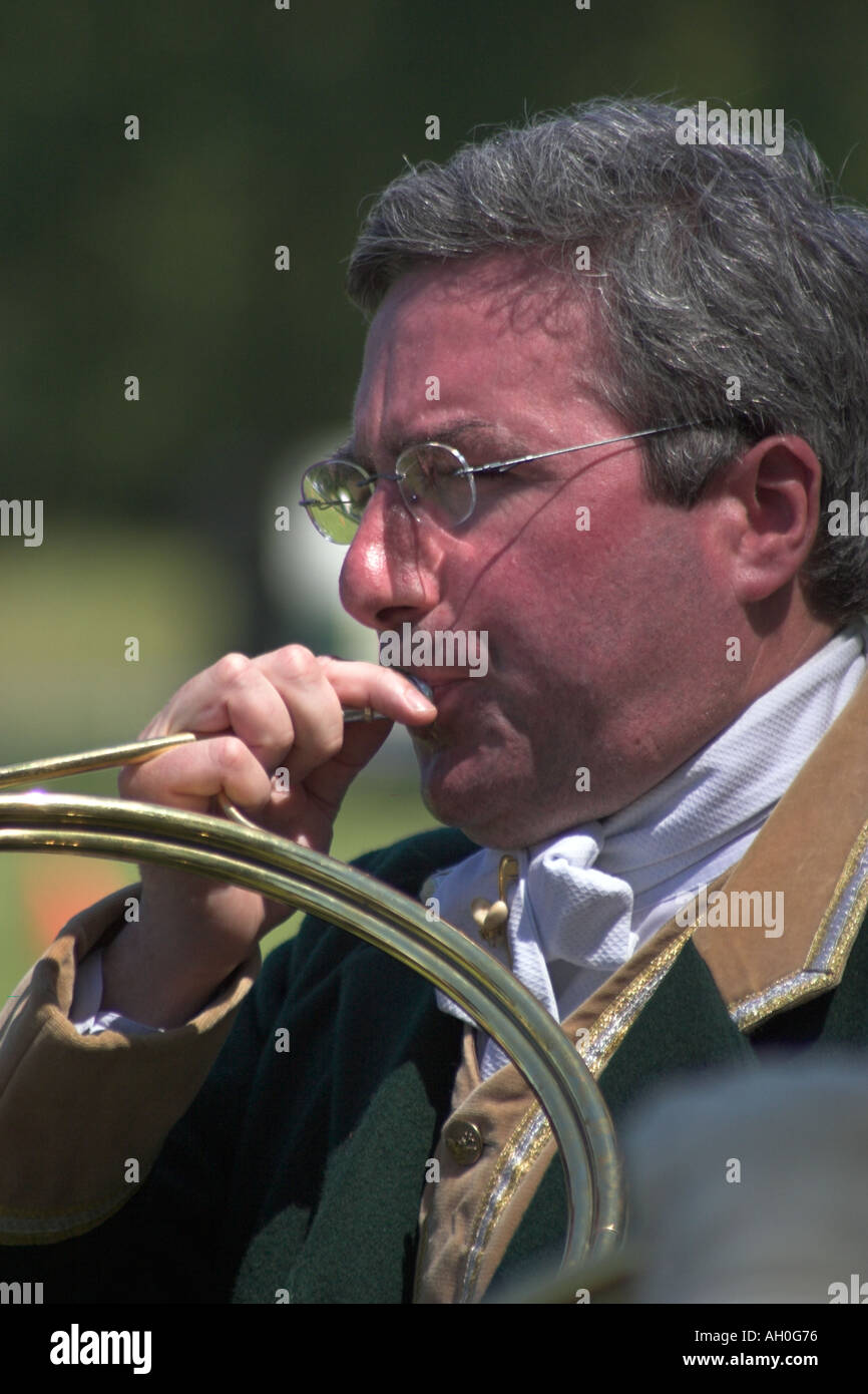 Male musician with french horn playing during ceremony at attelage