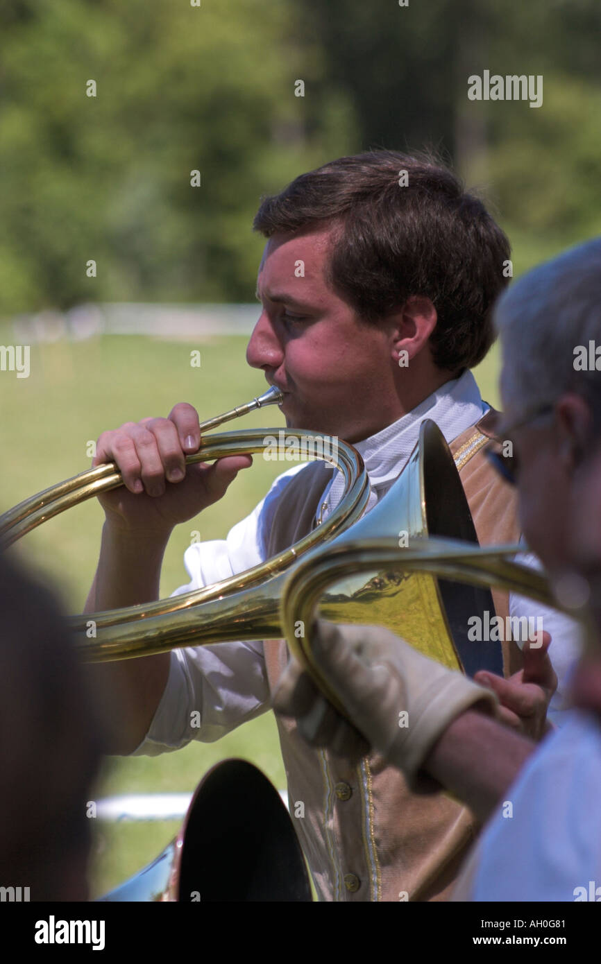 Male musician with french horn playing during ceremony at attelage