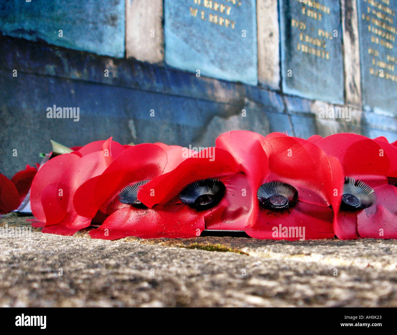 Poppies at the foot of a memorial in Lancashire England UK Stock Photo