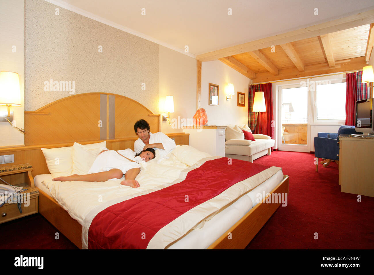 Couple wearing robes in hotel room relaxing Stock Photo Alamy