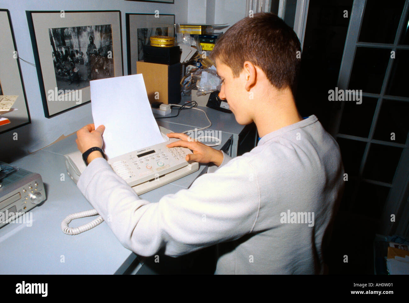 Work Experience 16 Year Old Boy Putting Fax In Machine Stock Photo