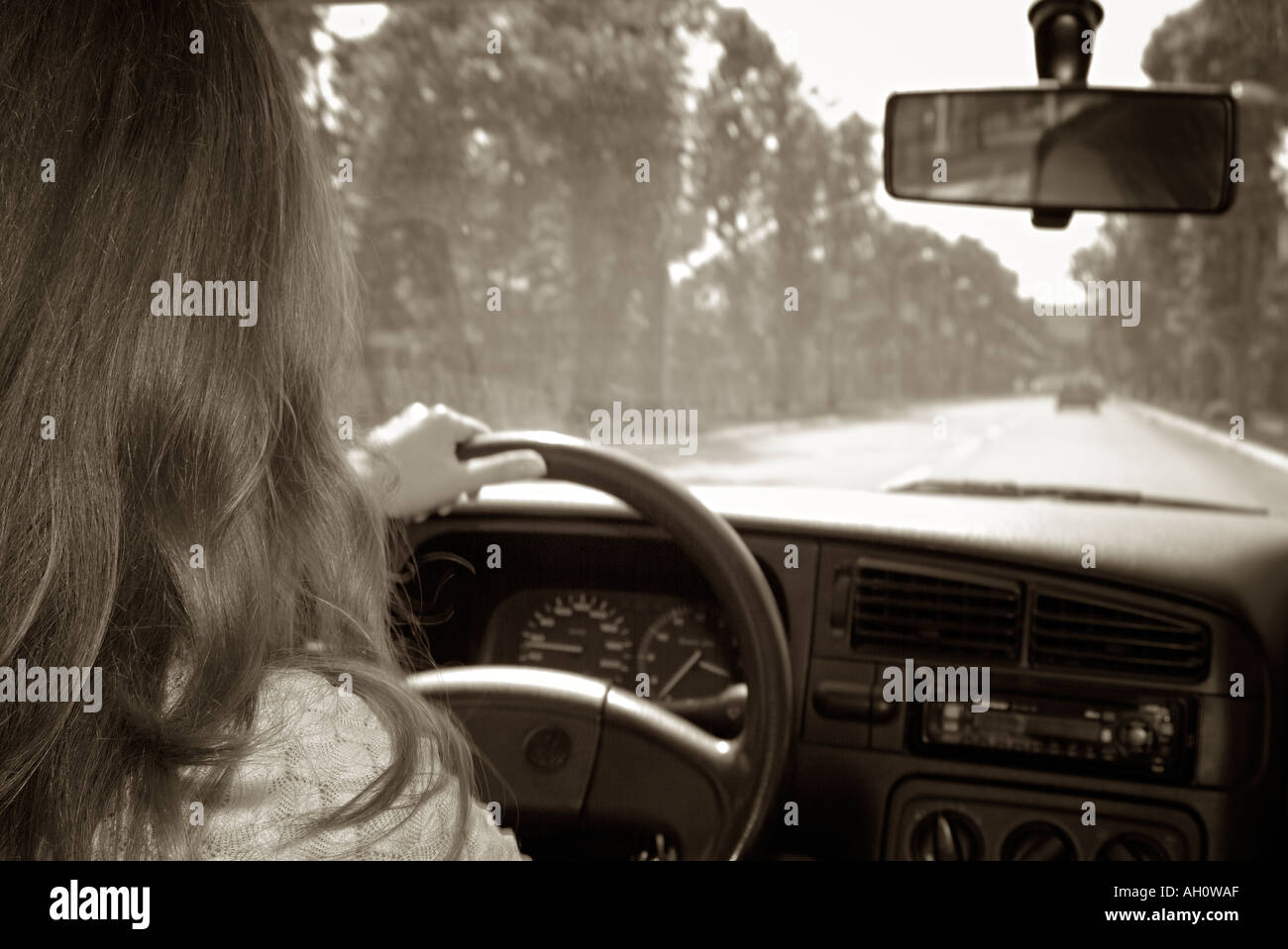Driving Woman Drives Her car Along an Urban Road Stock Photo