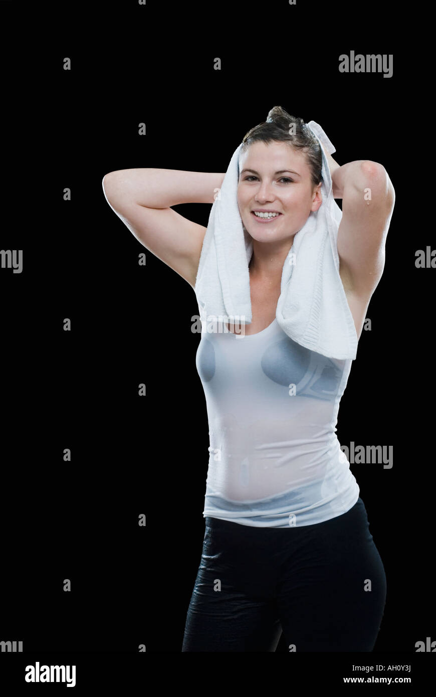 Portrait of a young woman drying her hair with a towel and smiling ...
