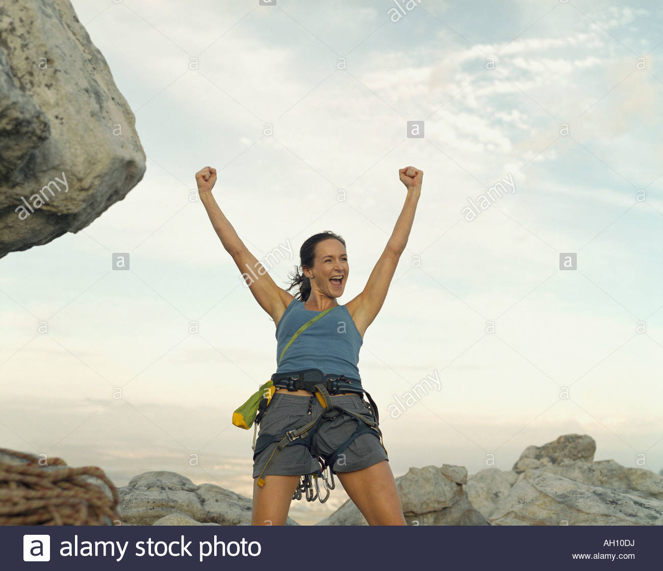 A woman climber at the top of a mountain victorious Stock Photo