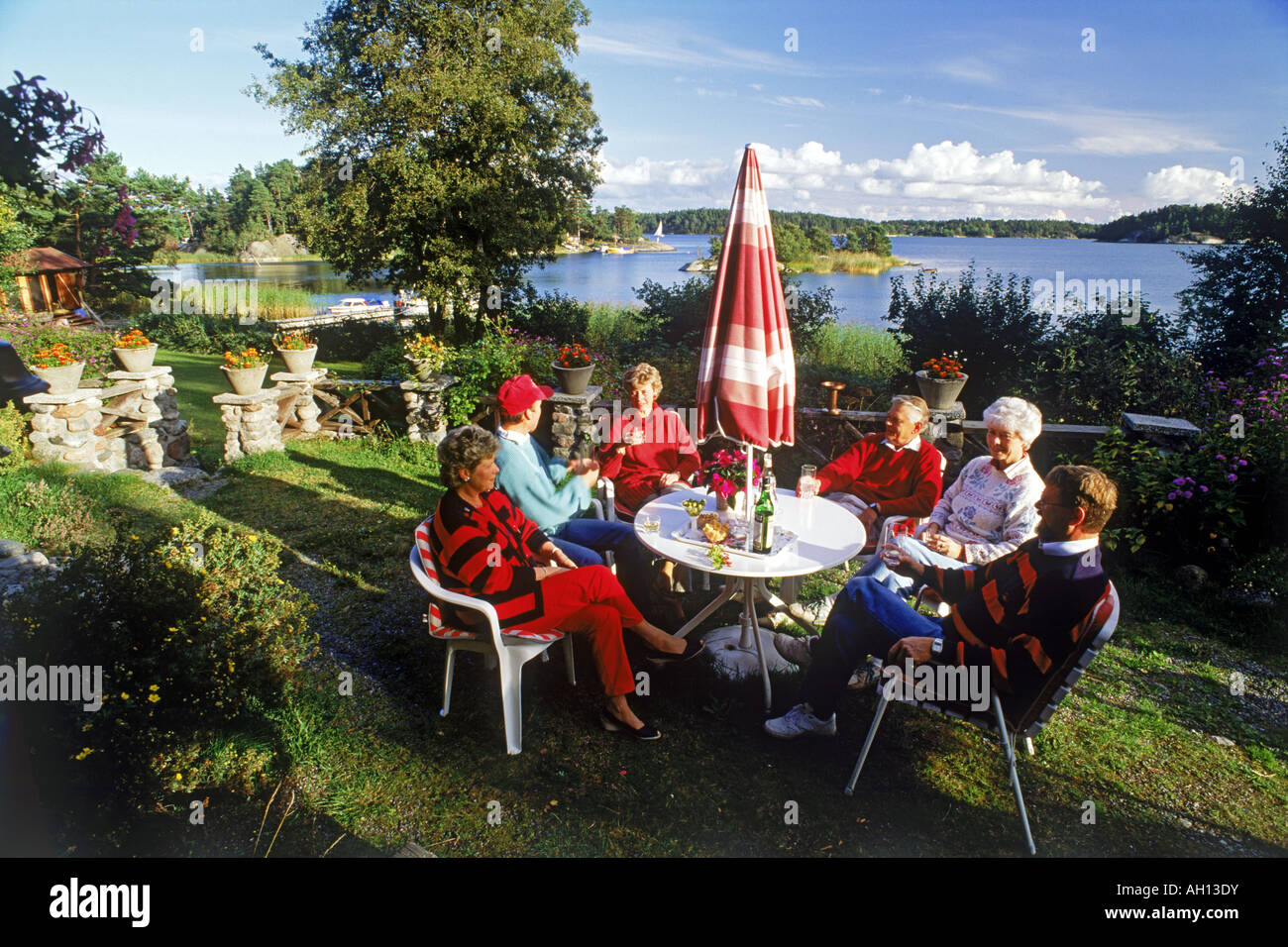 Friends sharing food and conversation on family owned island in Stockholm Archipealgo Stock Photo