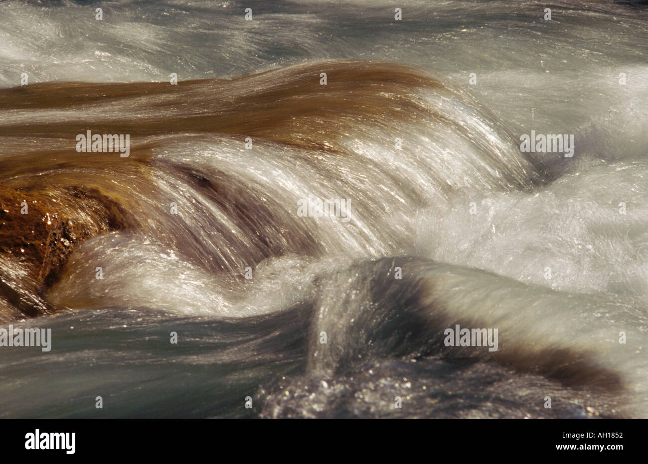 Water flowing over rock in river Stock Photo - Alamy