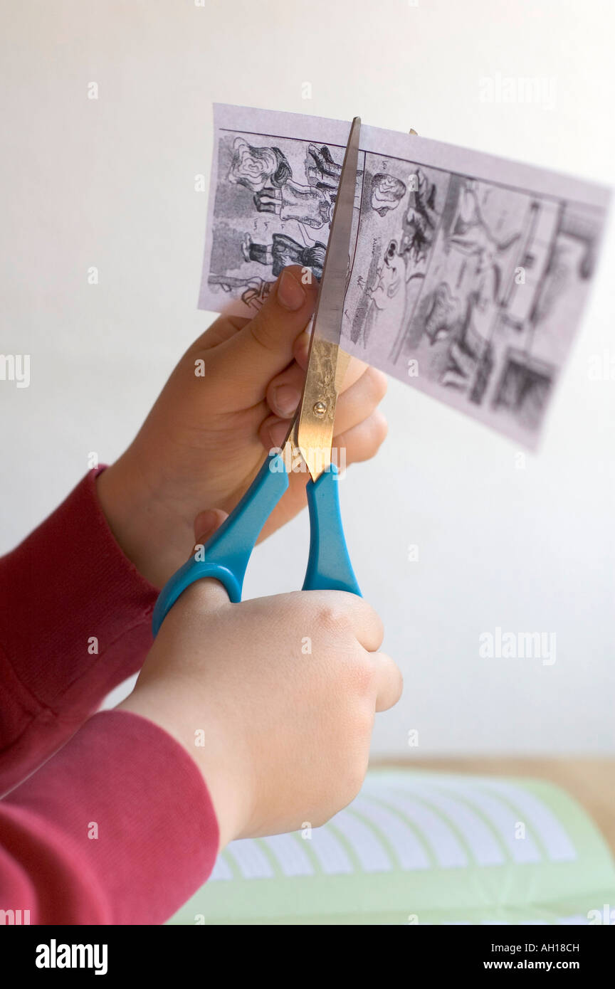 Homework child is cutting paper with scissors Stock Photo Alamy