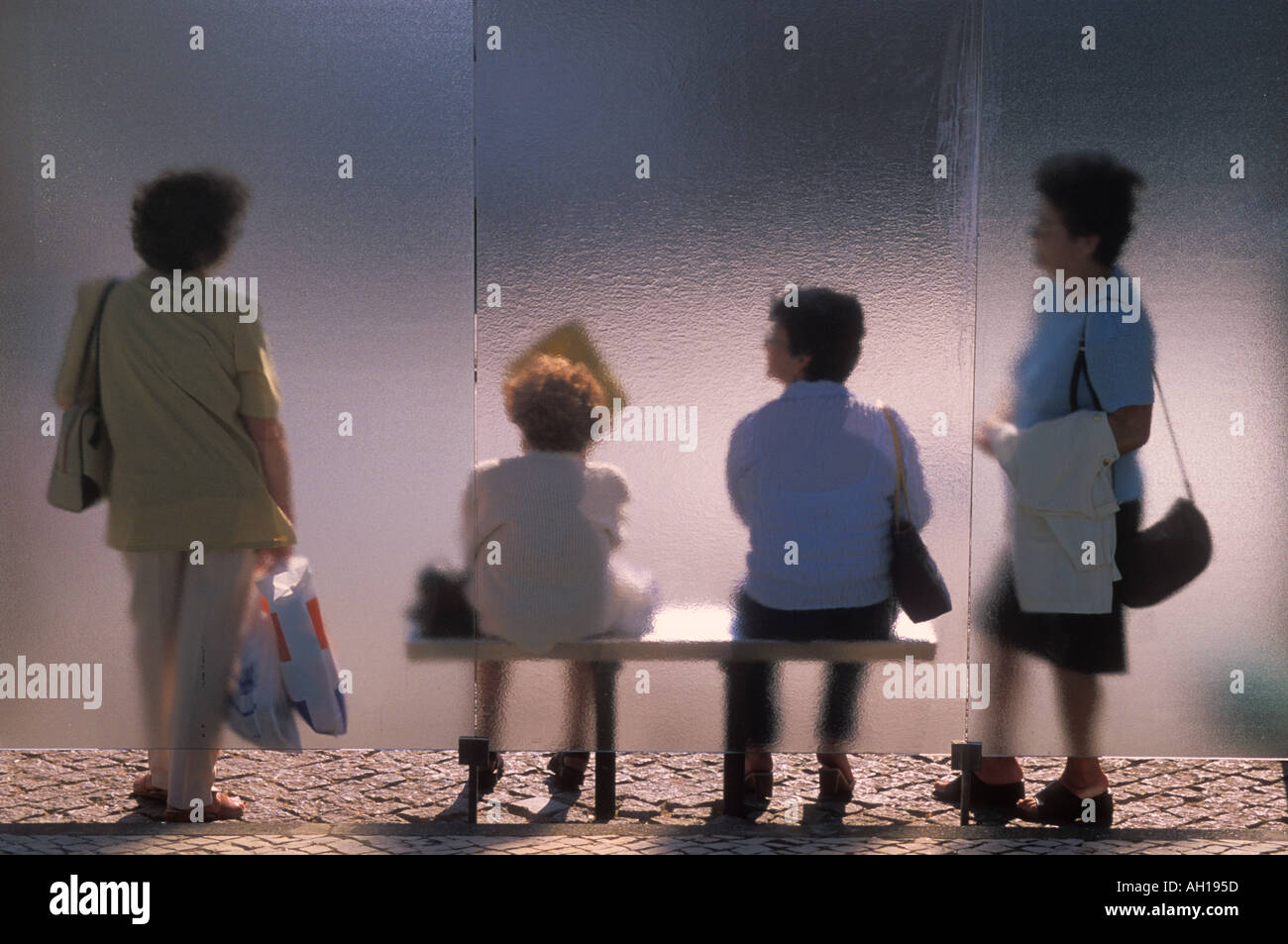 Four ladies waiting for a bus at a bus stop with a bus shelter in  Lagos Algarve Portugal EU Europe Stock Photo