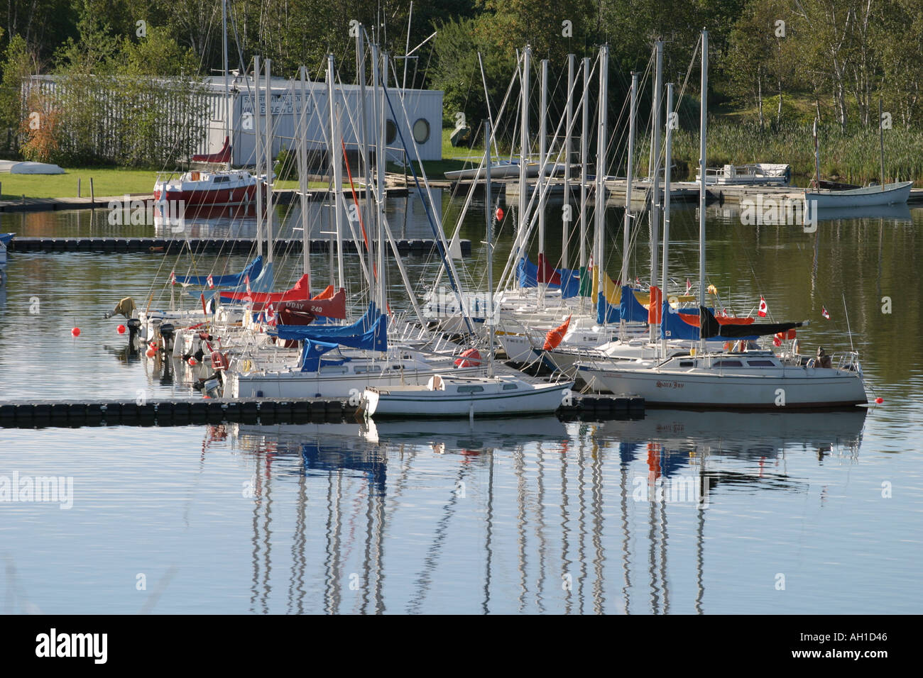 sailboats docked on lake with reflections in calm water Stock Photo - Alamy