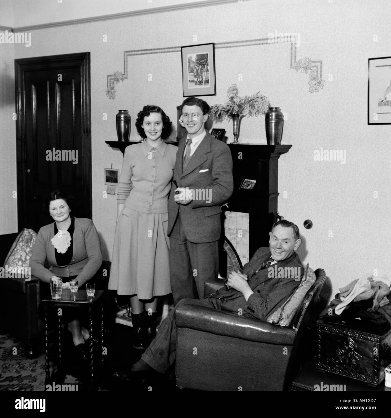 OLD VINTAGE FAMILY PHOTOGRAPH SNAP SHOT MARRIED COUPLE WITH PARENTS IN LIVING ROOM CIRCA 1950 Stock Photo