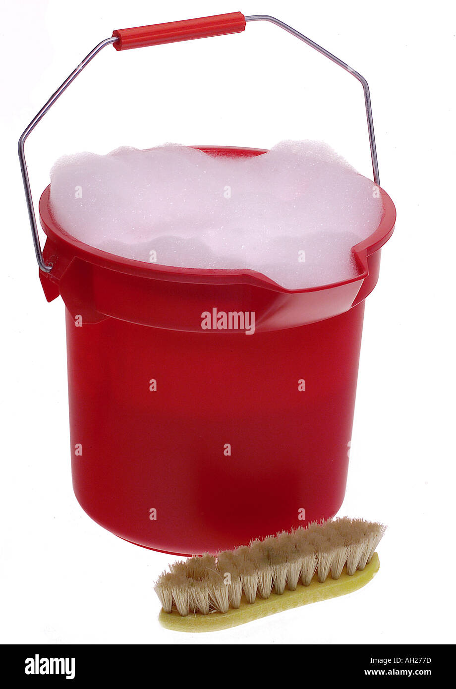 Red bucket of sudsy water and scrub brush silhouetted on white Stock