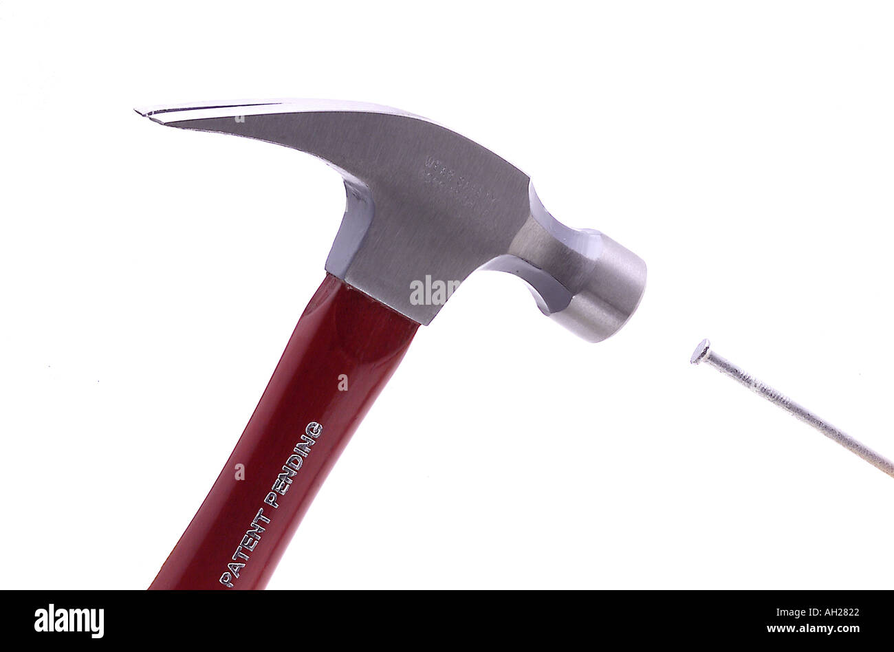 hammer hitting nail silhouetted on white background Stock Photo