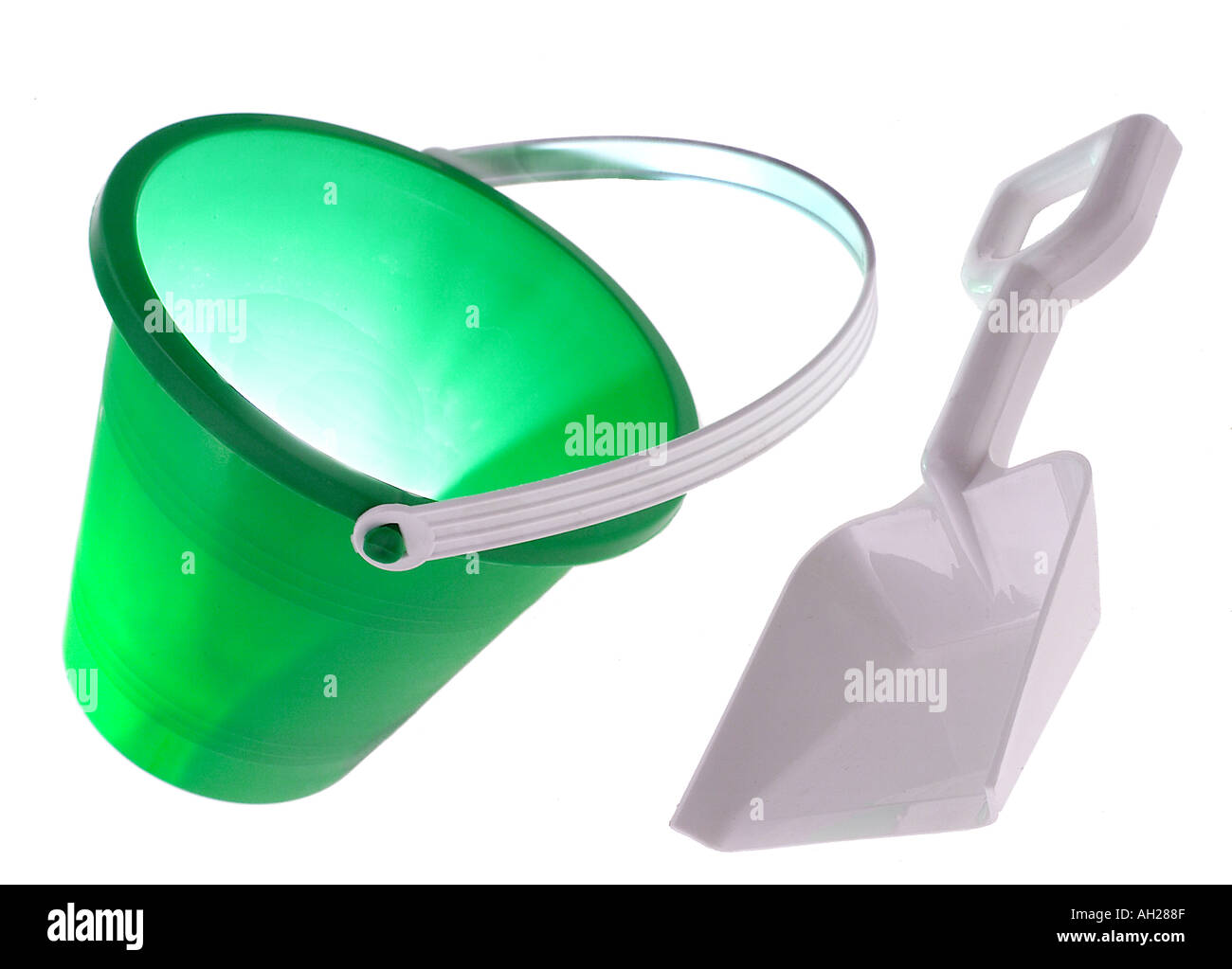 green pail and a white sand shovel silhouetted on white background