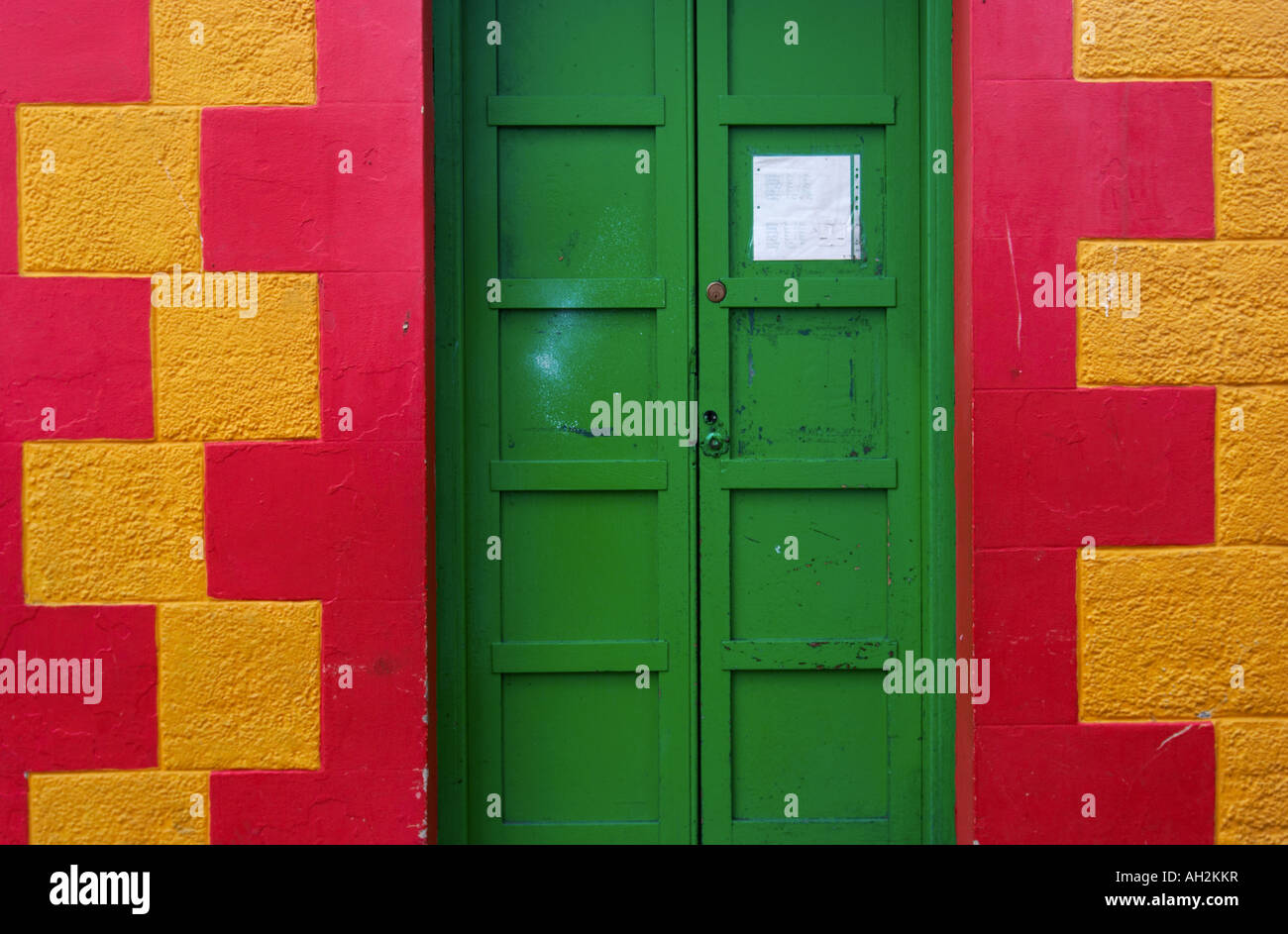 horizontal landscape photo of a green door in a red and yellow wall at the post office in Tobermory Stock Photo