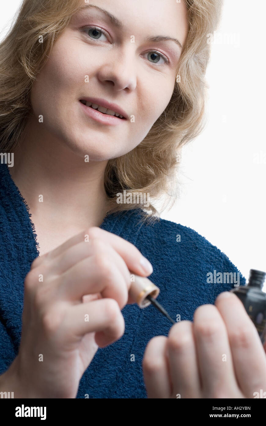 Portrait of a young woman applying nail polish Stock Photo