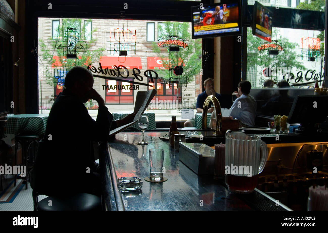 Man reading newspaper at a Chicago restaurant bar. Stock Photo
