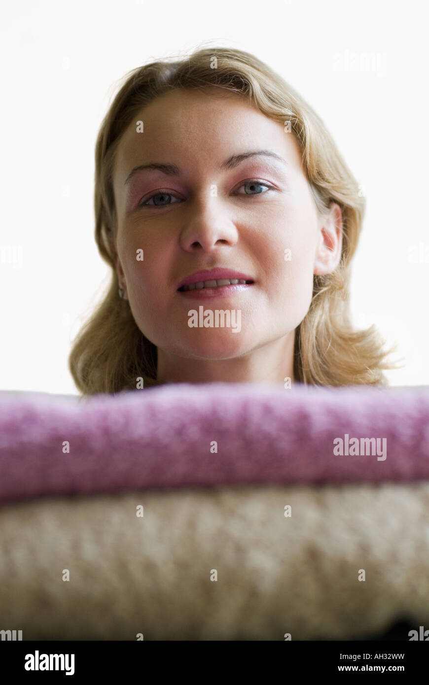 Portrait of a young woman with a stack of towels Stock Photo - Alamy