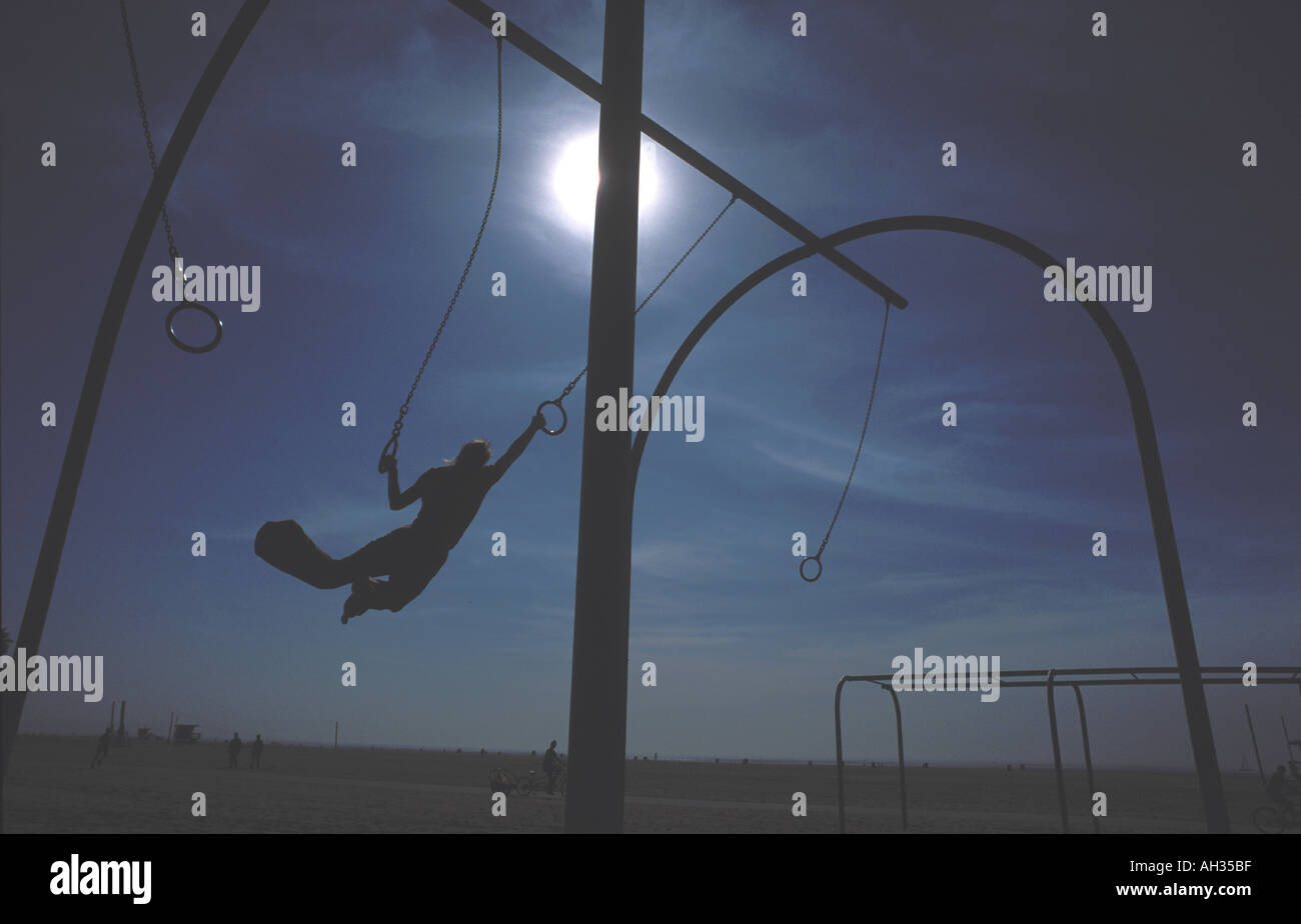 Gymnast swinging on rings at Santa Monica beach, Los Angeles, U S A ...