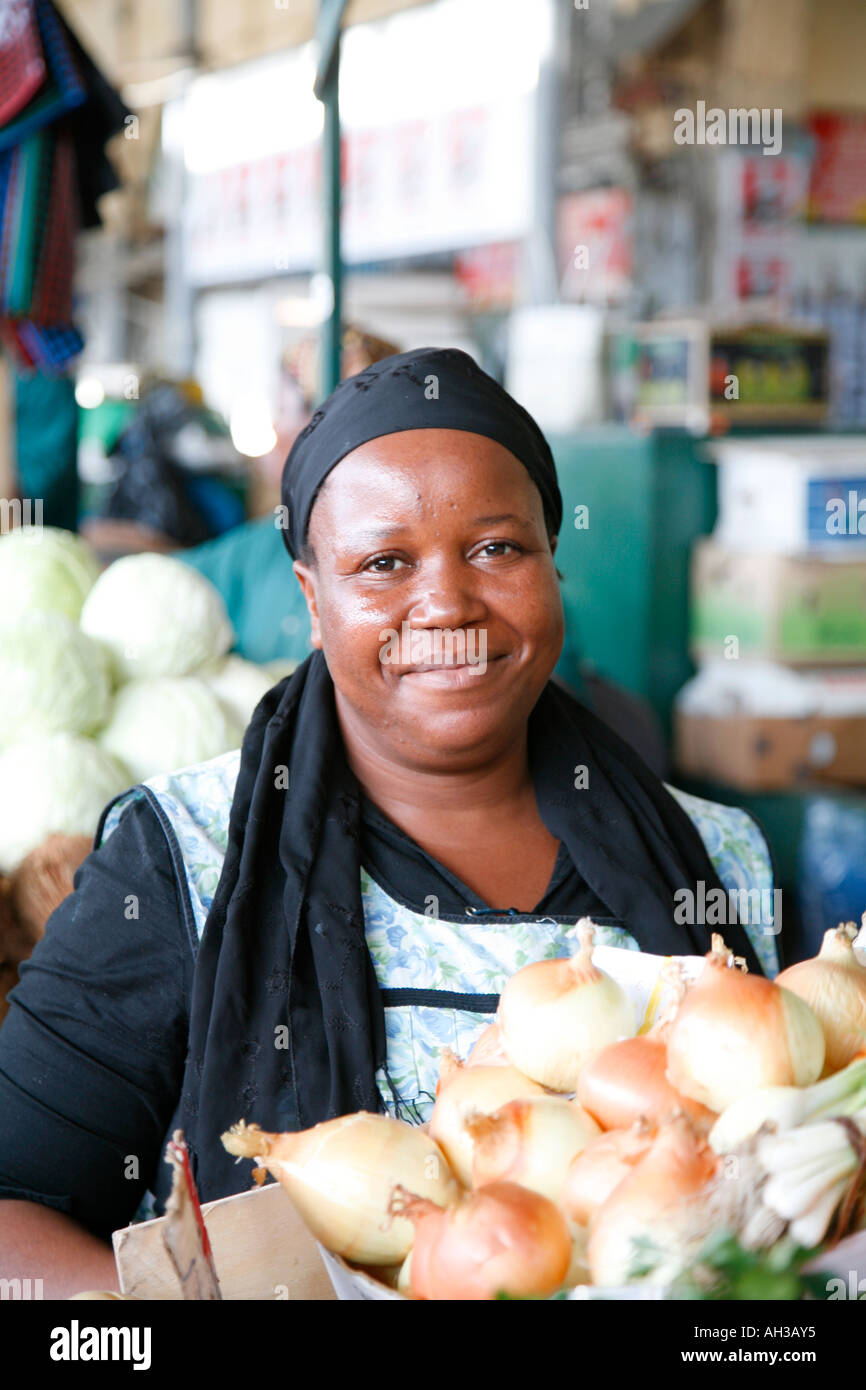Environmental portrait of friendly smiling black African woman selling vegetables at Maputo Central Market (Mercado Municipal) in Maputo, Mozambique Stock Photo
