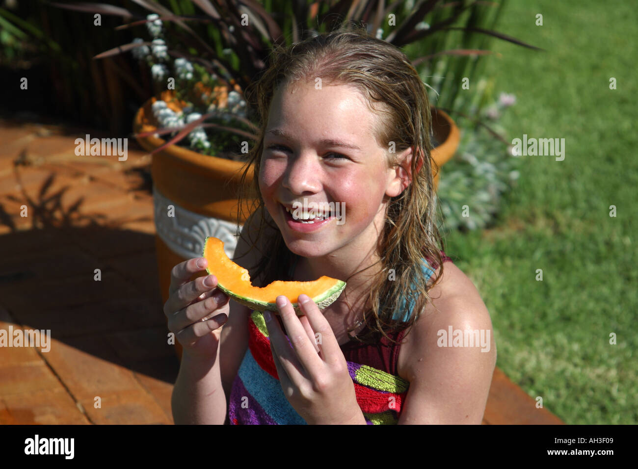 beautiful young girl eating melon slice Stock Photo