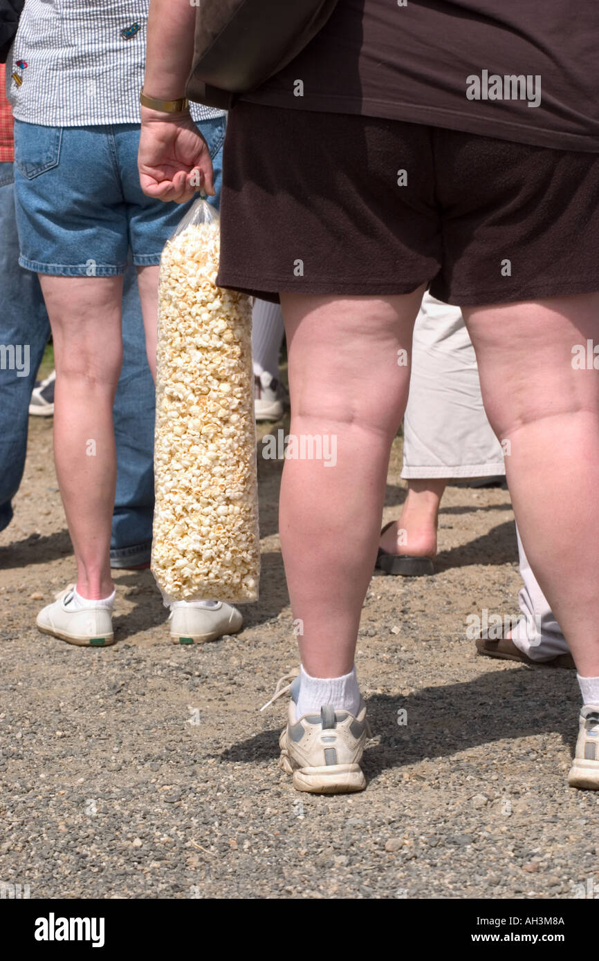 Woman with big thighs holding a larg bag of popcorn Stock Photo - Alamy