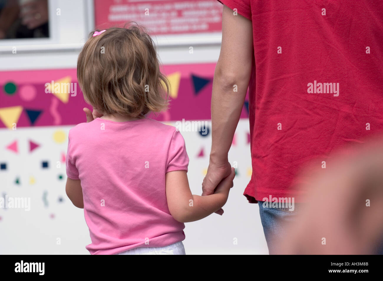 Young girl walking hand in hand with her father Stock Photo - Alamy
