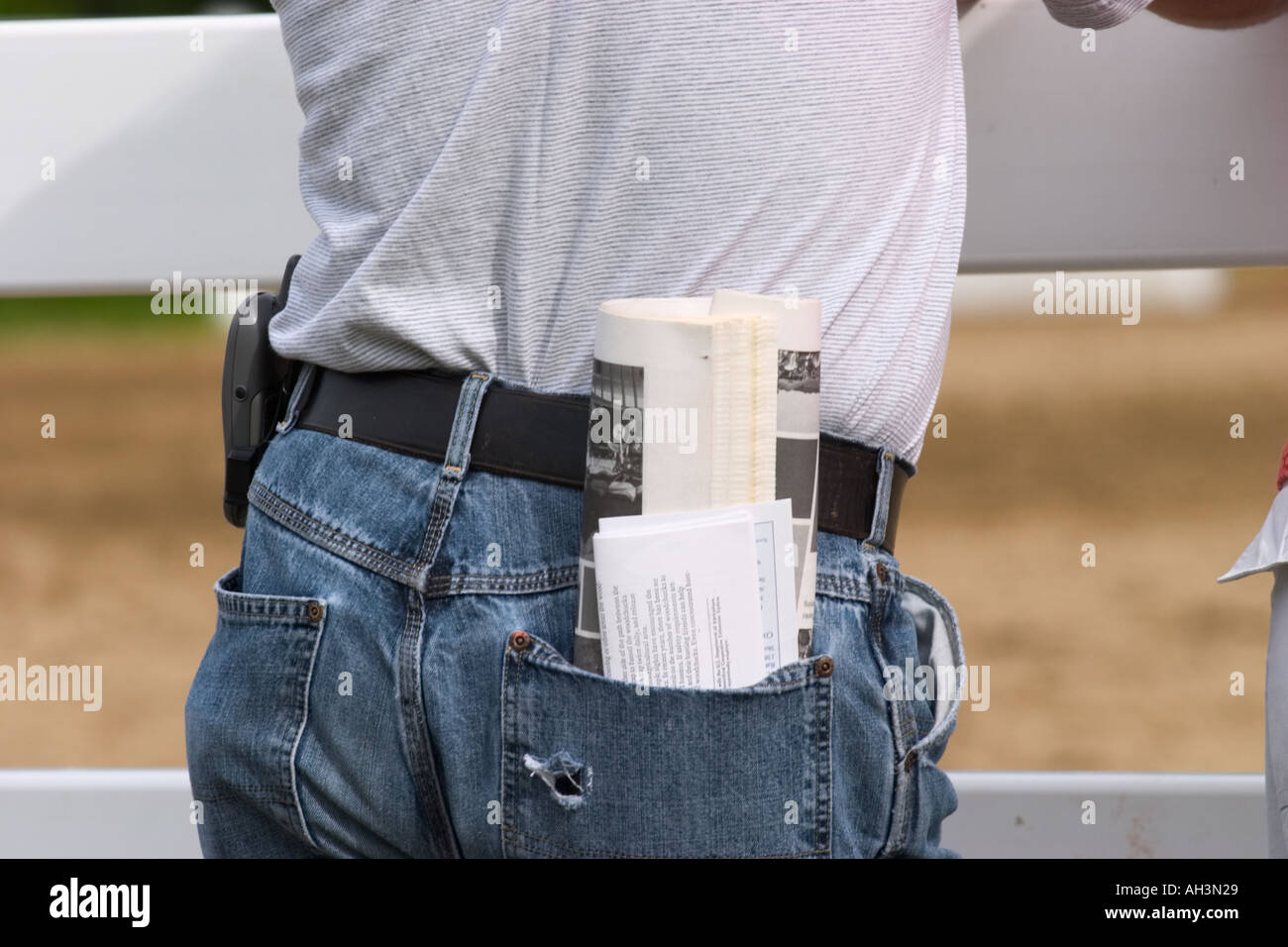 Man Carefully Places Piece Of Paper In Back Pocket To Make Sure It