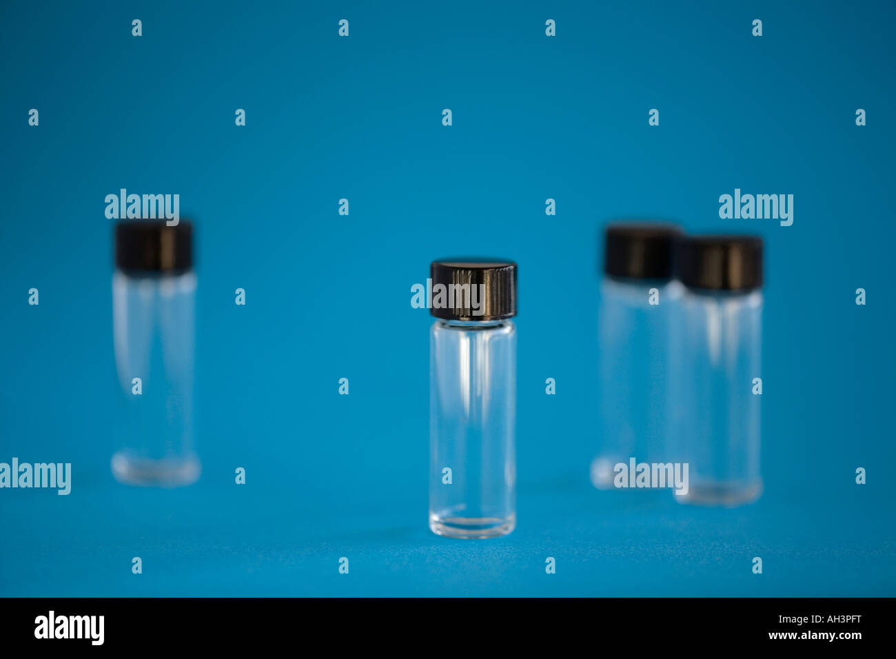 Small glass vials on blue background Stock Photo Alamy