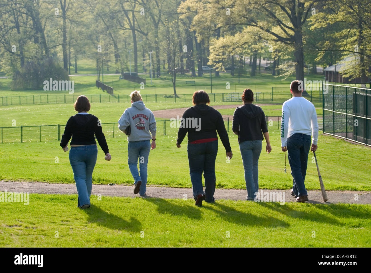 Young women and a man walking in the park Stock Photo - Alamy