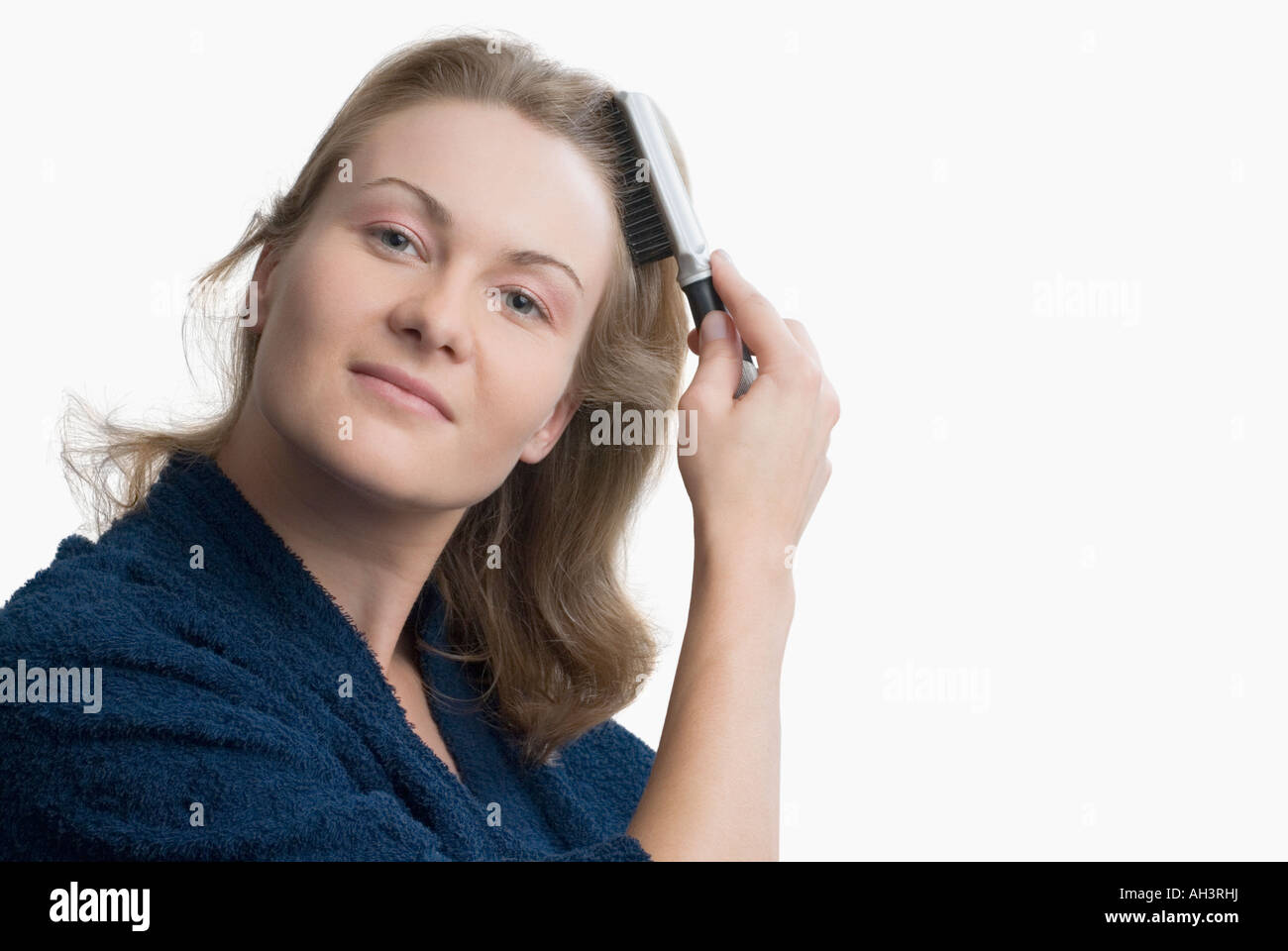 Portrait of a young woman brushing her hair Stock Photo