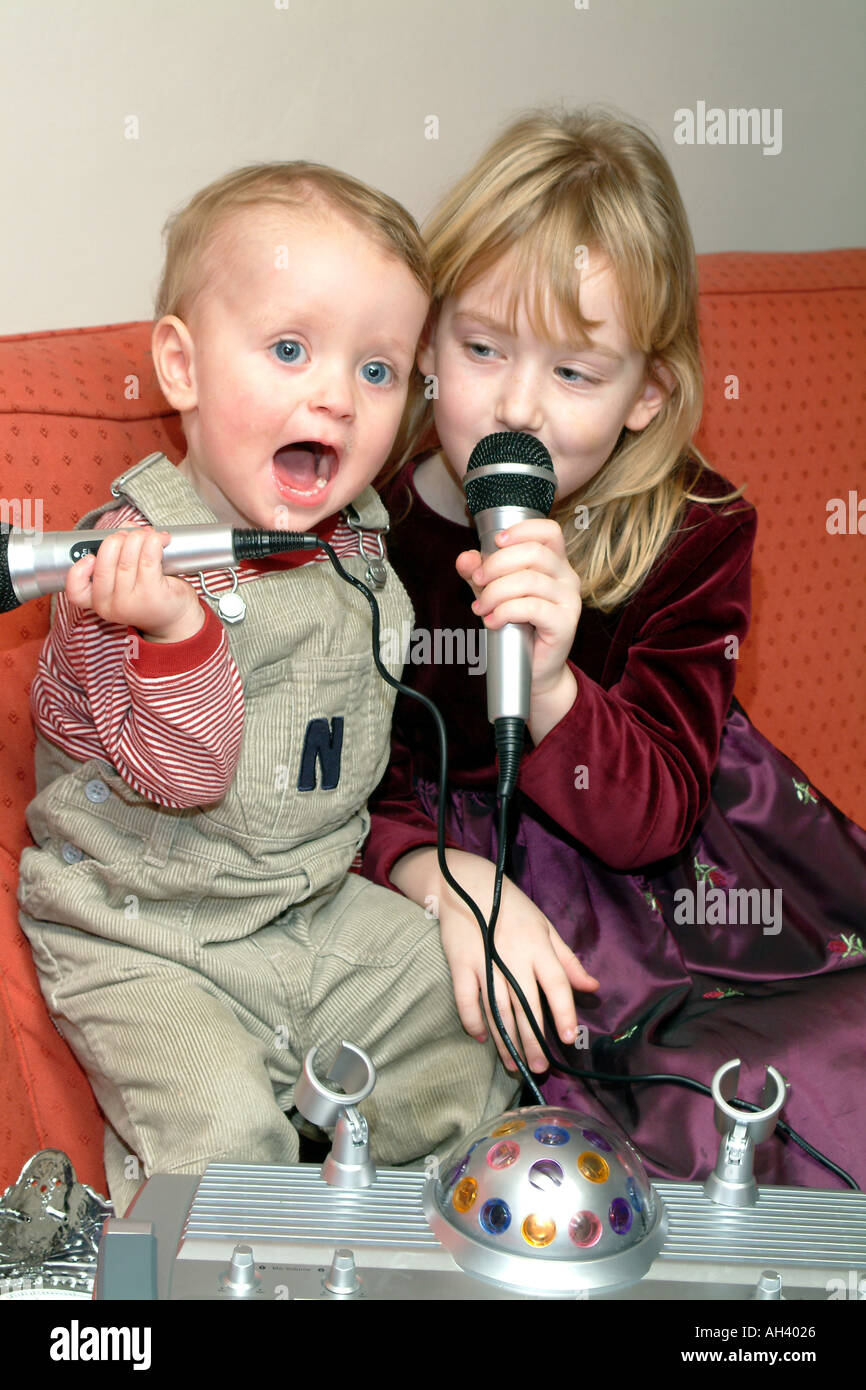 Karaoke Young Children Singing to Backing Music Singalong Stock Photo