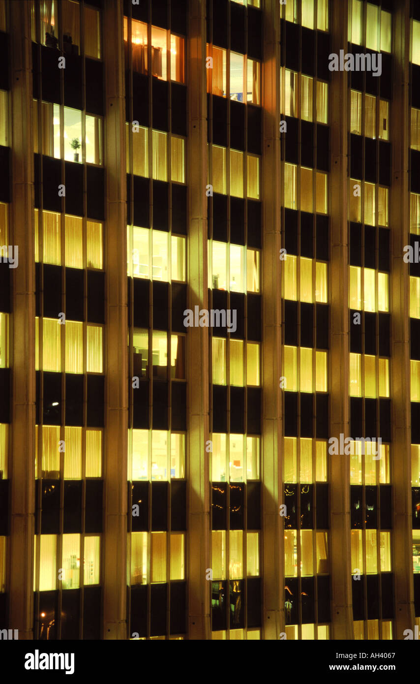 CLOSE UP VERTICAL ABSTRACT OF A WELL LIT OFFICE BLOCK AT NIGHT Stock Photo