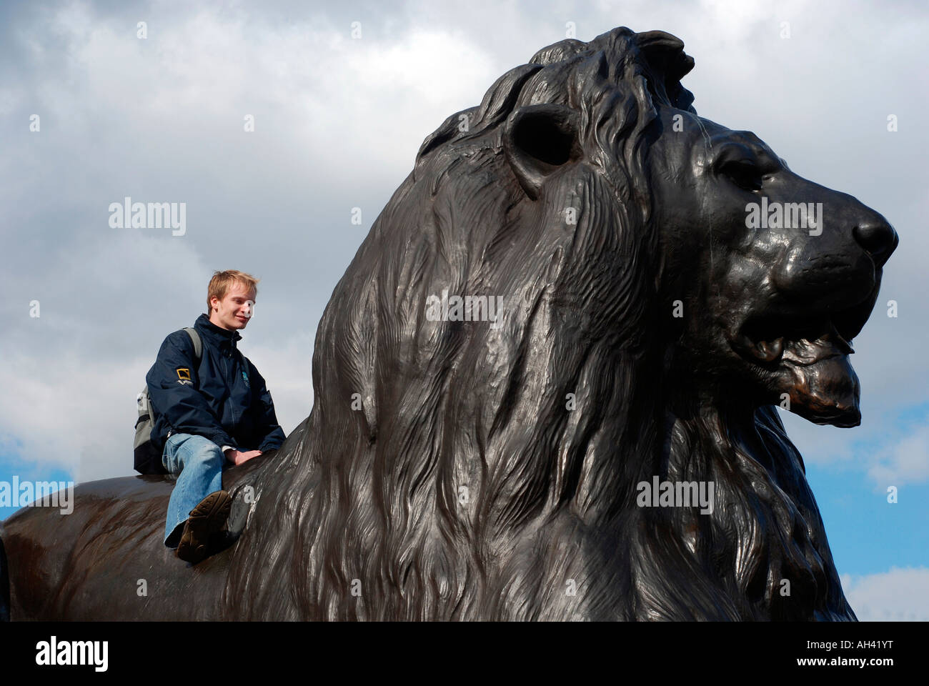 Tourist sitting on a Trafalgar Square Lion Stock Photo