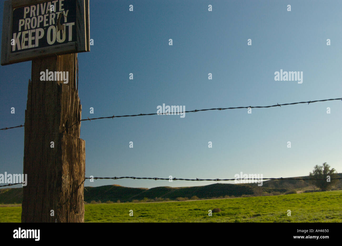 Barbed wire fence with no trespassing sign Stock Photo - Alamy
