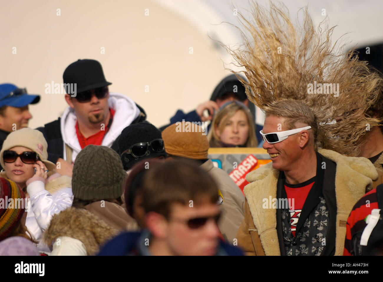 A smiling man with a mohawk haircut and sunglasses in a crowd at the ESPN Winter X Games Buttermilk Mountain Ski Area, Aspen, CO Stock Photo