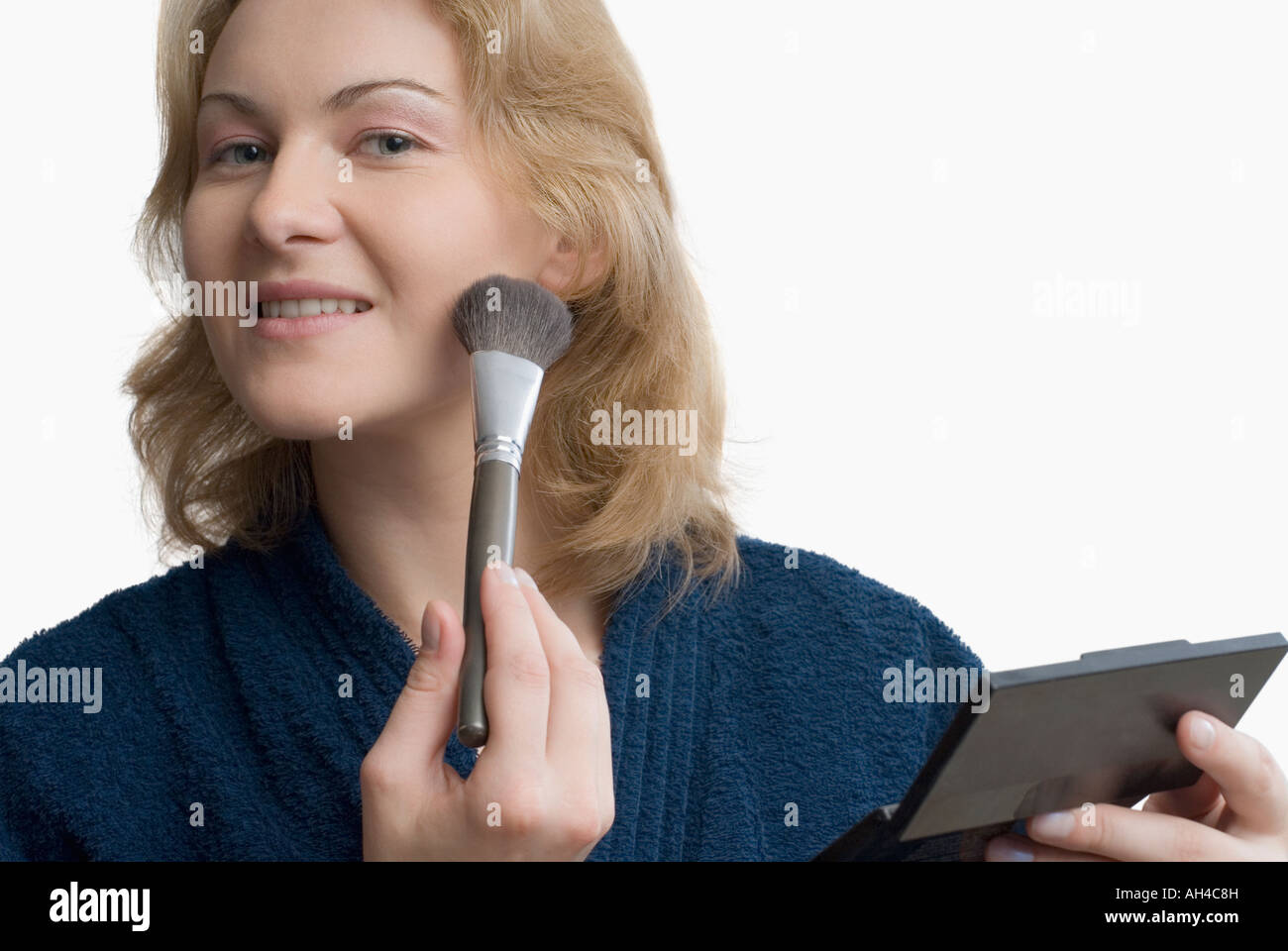 Portrait of a young woman applying make-up with a brush Stock Photo