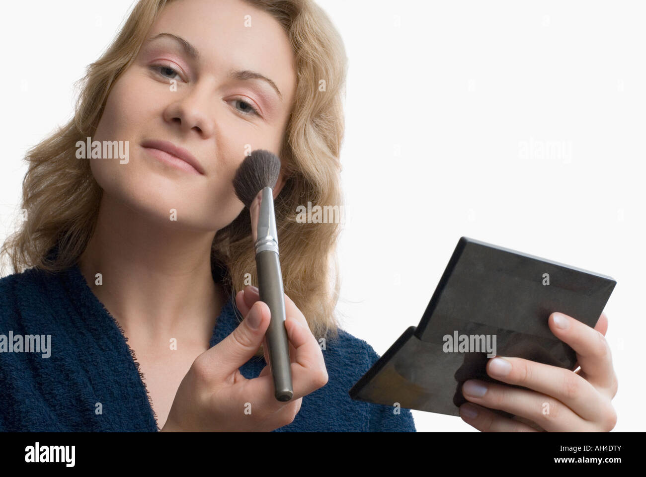 Portrait of a young woman applying make-up with a brush Stock Photo