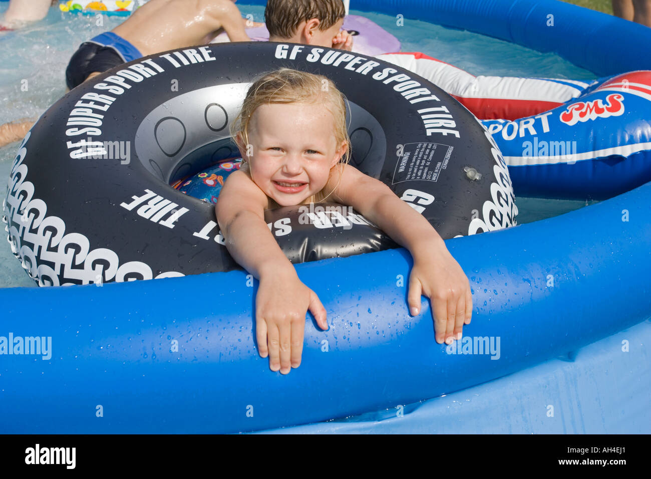 Four year old Grace in blown up inner tube in inflatable garden