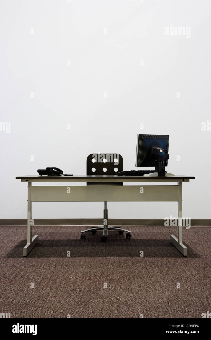 Bare office desk with computer and phone Stock Photo