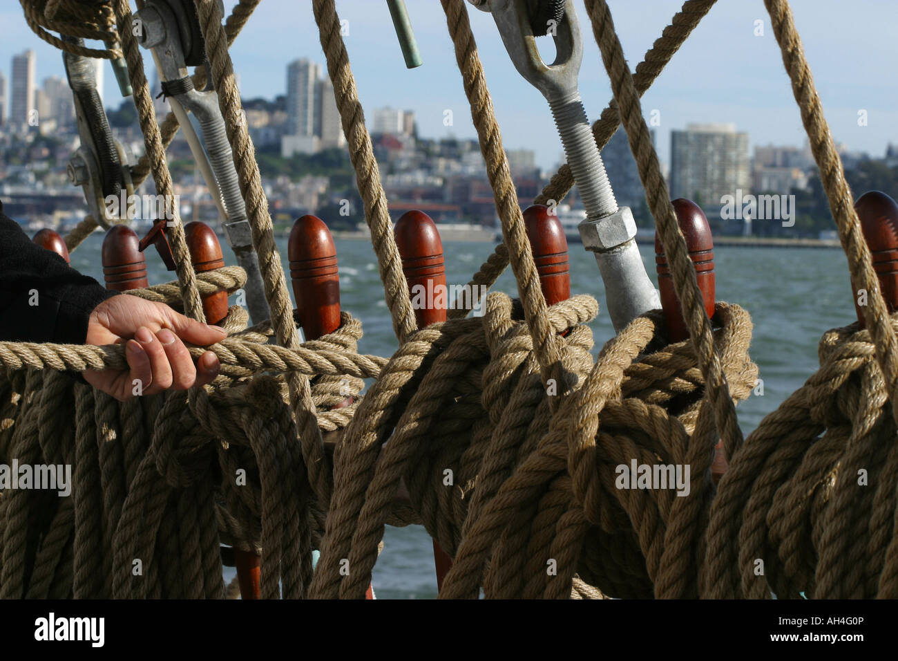 Hand of sailor pulling the line around the holds to pull up the sail in