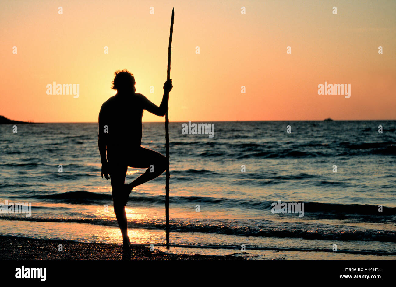 aboriginal with walking stick gazing at the sea, Darwin, Australia Stock Photo