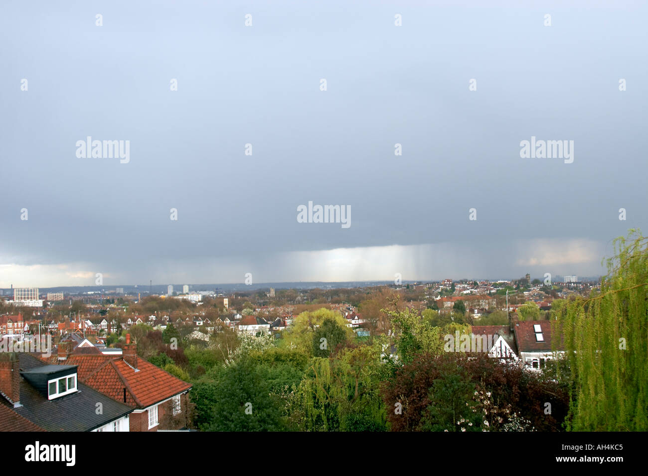 View east across suburbs and rooftops of north London from Muswell Hill with rain falling from